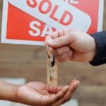 person handing out keys to another person